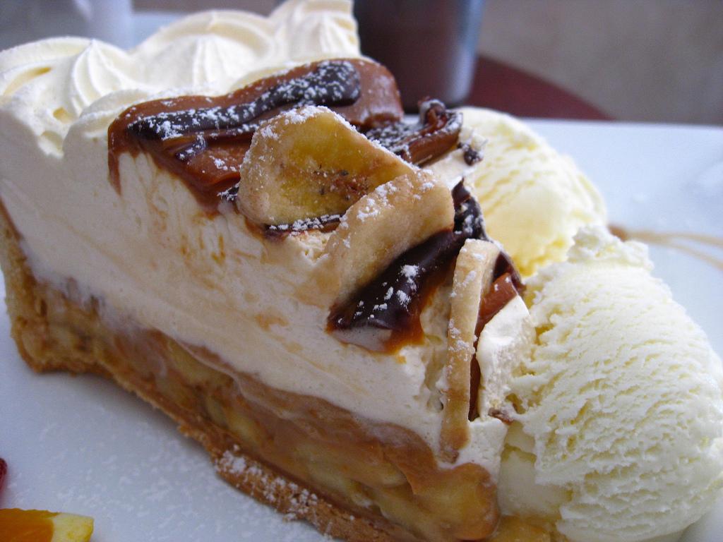 A slice of banoffee pie with bananas, toffee and cream