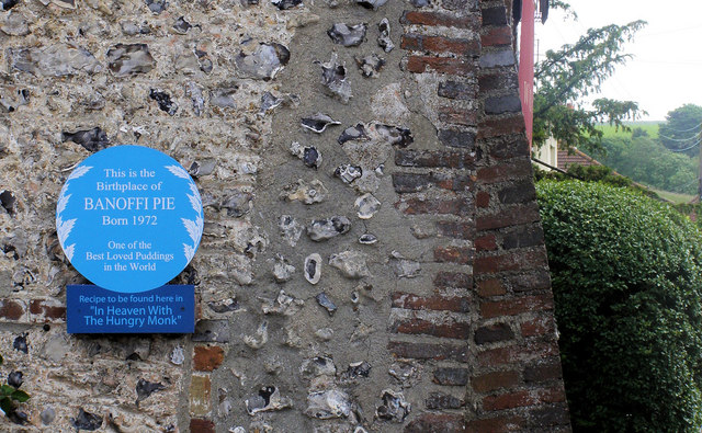 Blue plaque on a flint wall reading This is the Birthplace of Banoffi Pie, Born 1972
