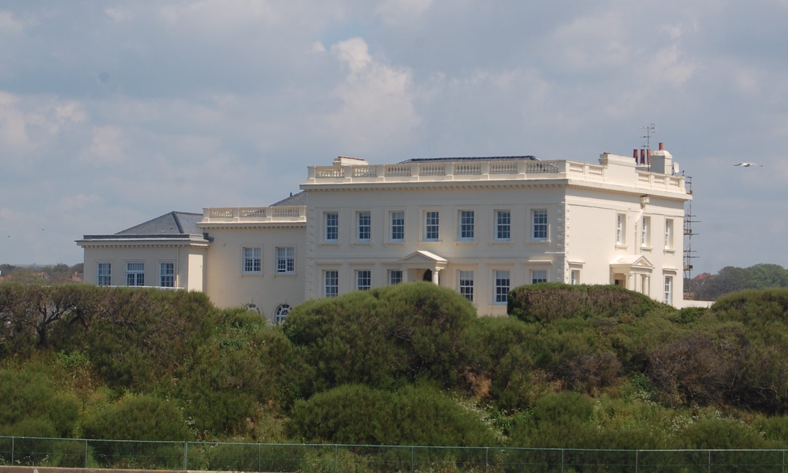 Corsica Hall, a white stucco Georgian house with a balustraded parapet, on College Road, Seaford