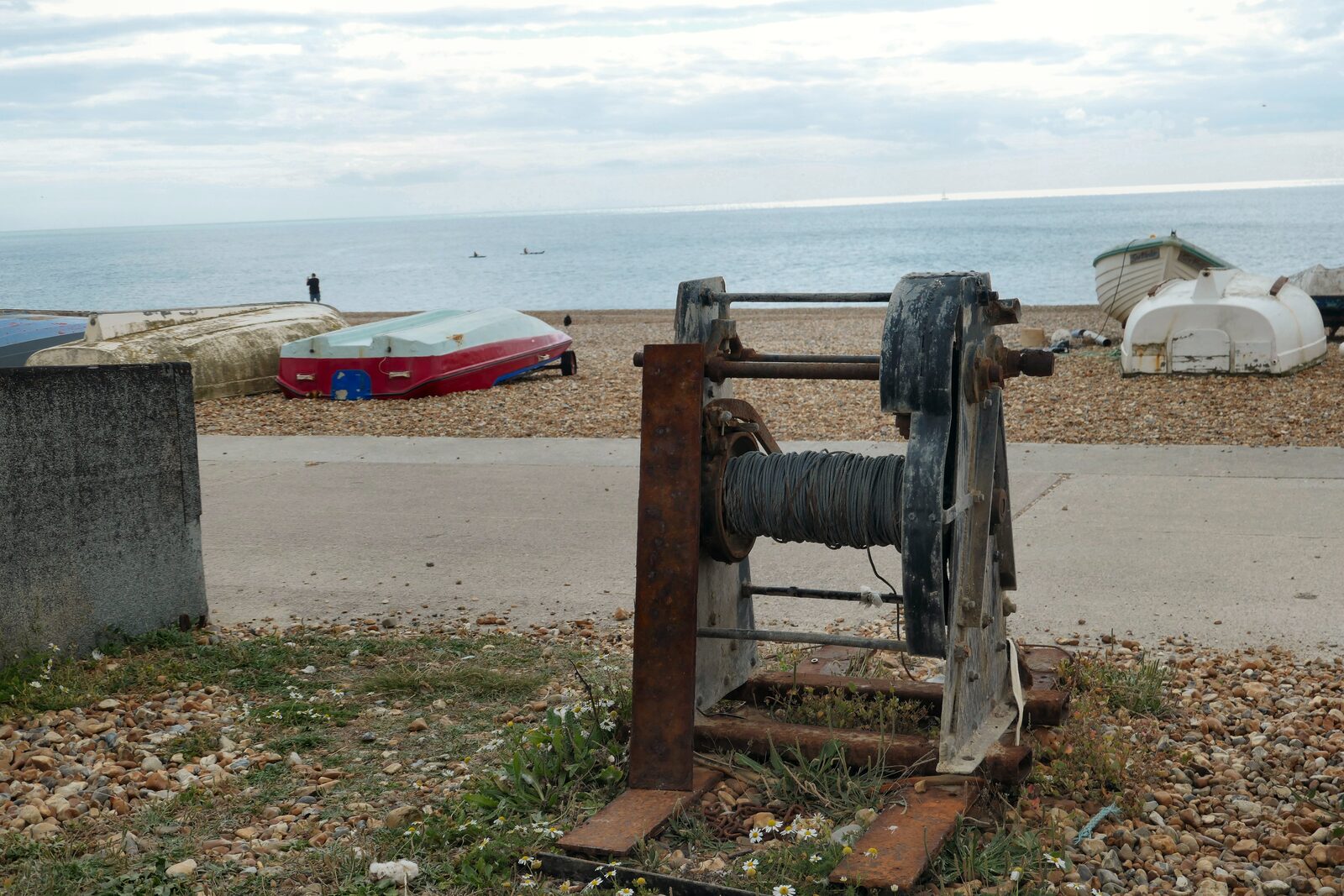 Small fishing boats and a winch on the shingle at the eastern end of Seaford beach